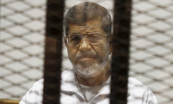 Egypt’s ousted Islamist president Mohamed Morsi sits in a cage in the police academy courthouse in Cairo