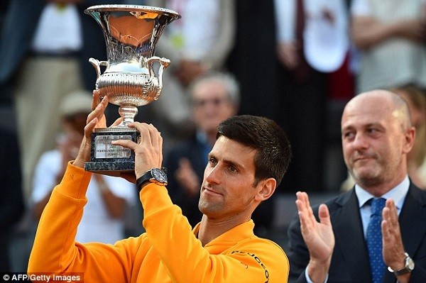 Novak Djokovic lifts the Italian Open trophy after retaining his title in straight sets against Roger Federer