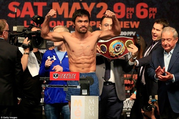 Pacquiao flexes his muscles on the scales and came in at two pounds under the weight limit