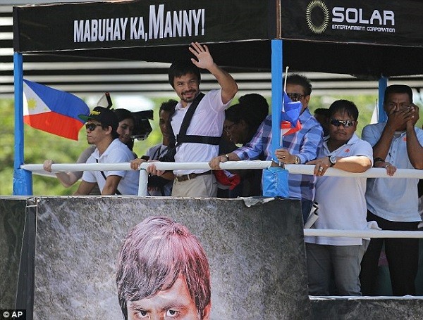 Pacquiao was seen back home on top his open top bus with a sling on his right arm