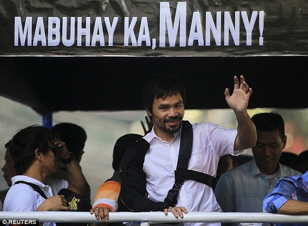 Pacquiao waves to the crowd from on top an open tour bus in Manila, the capital of the Philippines