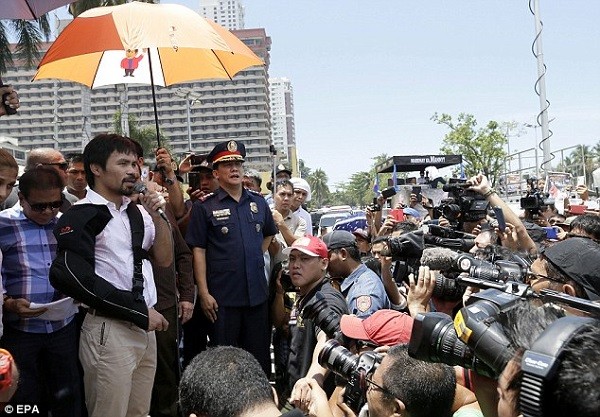 Spectators and cameramen gather in Manila for a welcoming parade on Pacquiao's return home