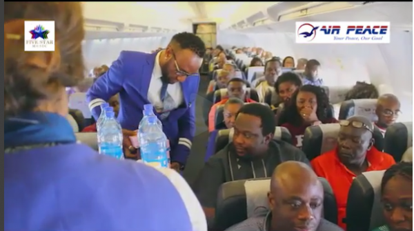 (Kcee serving drinks aboard Air Peace. Photo: Five Star)