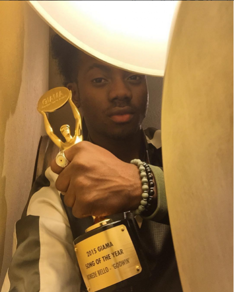 (Kode Bello strikes a pose with his award.)