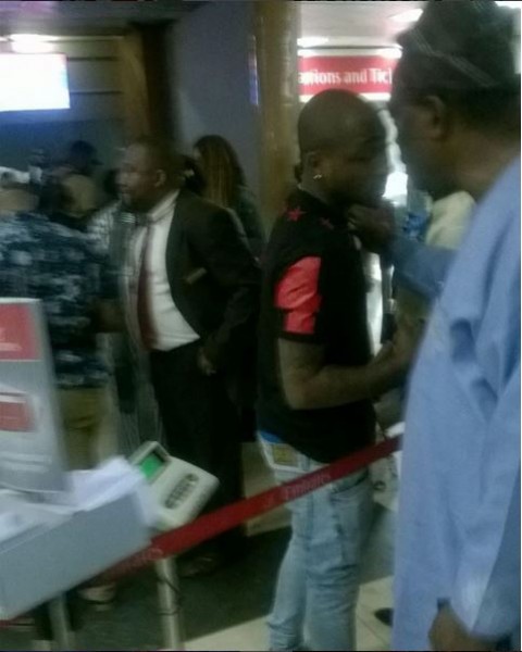 Davido at the airport being consoled by an Uncle when he couldn't travel out of the country with his daughter.