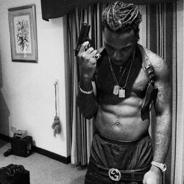 Burna Boy poses with a caliber gun