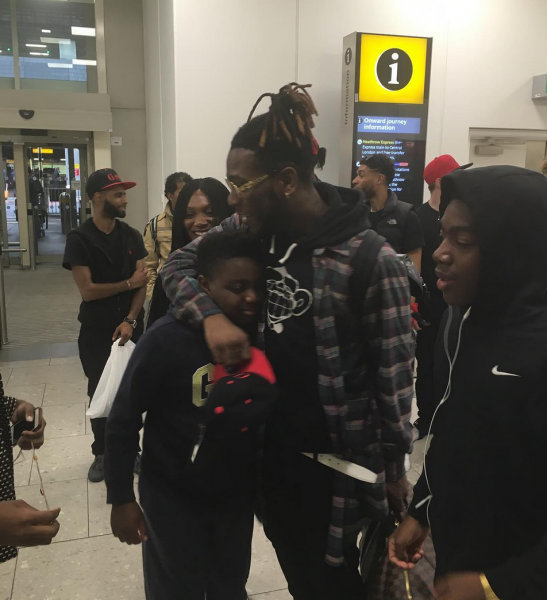 Burna Boy greeting fans as he arrived UK.