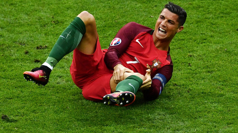 Ronaldo reacts before medics arrive on the pitch during the Euro 2016 final football match between Portugal and France. Credit: AP