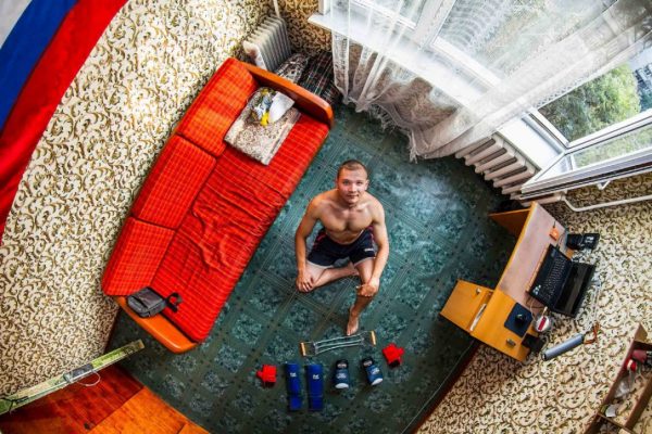 Oleg, a 23-year-old engineer from Novosibirsk, Russia pictured in his bedroom (Photo: John Thackwray)
