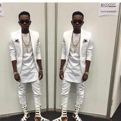 patoranking wearing a pair of white gladiators