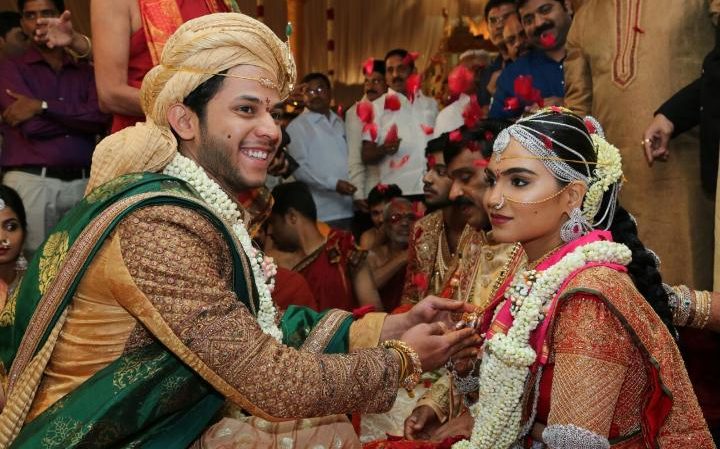 Bramhani (R) sits with her groom, Rajeev Reddy during their wedding