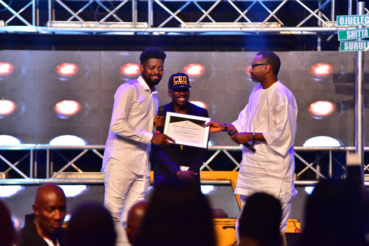 Basketmouth receiving the award on stage.