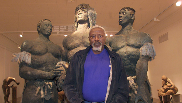 Sow stands before some of his sculptures. Photo- AFP