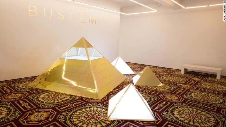 The sneakers are housed in gold-gilded pyramid